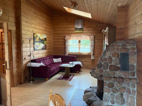 a living room with a couch and a stone fireplace at Ferienhaus Hohenlubast in Gräfenhainichen