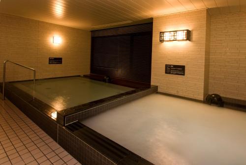 a empty bathroom with a large tub in a room at Dormy Inn Nagasaki Shinchichukagai in Nagasaki