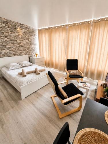 a bedroom with a bed and chairs in a room at Petit Nid Nature Et Douceurs in Turckheim