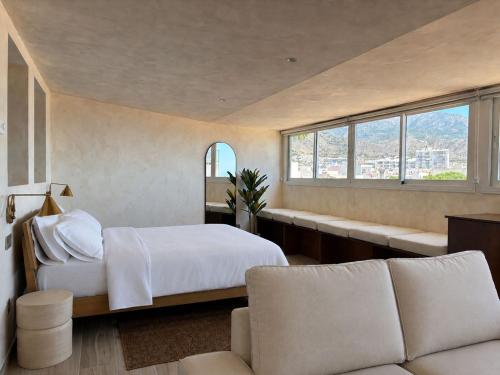 a bedroom with a bed and a couch and windows at Pensión Sevillano in Nerja