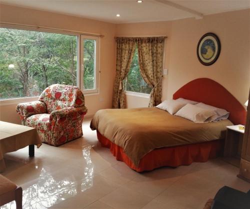 una camera da letto con un letto, una sedia e una finestra di Familia Piatti B&B - Suites a Ushuaia