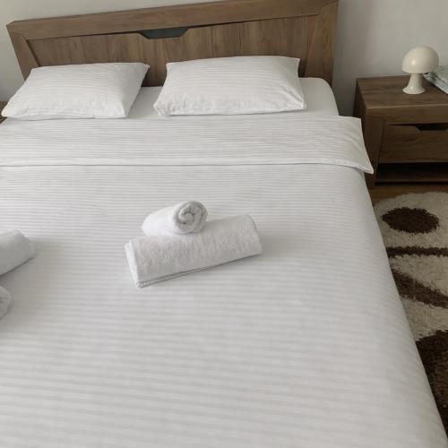 a white bed with a towel on top of it at Woodside House in Solotvyno
