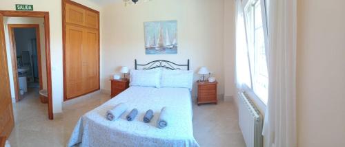 a bedroom with a bed with two pairs of slippers at Sunrise Hill Guest House in Los Gallardos