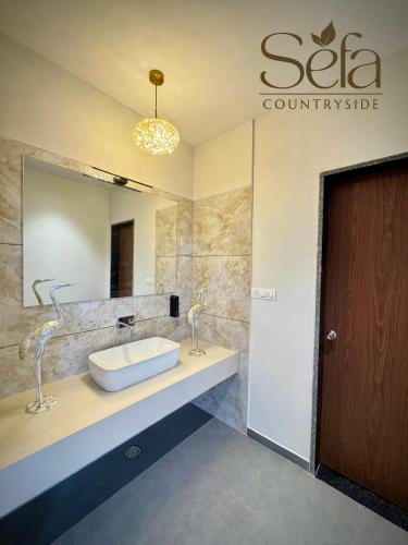 a bathroom with a sink and a mirror at Sefa Countryside in Sukhi Sewānia