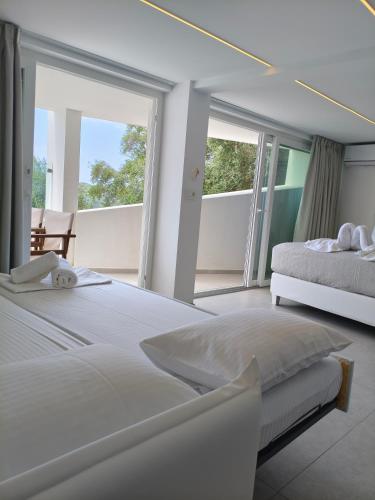 ein Schlafzimmer mit zwei Betten und Balkon in der Unterkunft Kanali Studios in Parga