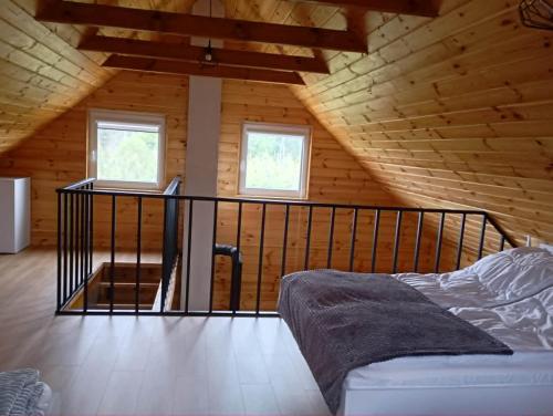 a bedroom with a bed in a wooden cabin at Przystanek Ładnówko in Kruszyny Szlacheckie