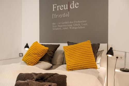 a bed with two yellow pillows on top of it at Mola Apartments- Trendiges Apartment in der City-Nähe Dortmund-Terrasse-3 Gäste-WLAN in Herdecke