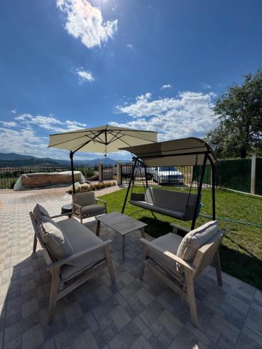 a patio with two chairs and an umbrella at Къща за гости Пегас in Velingrad
