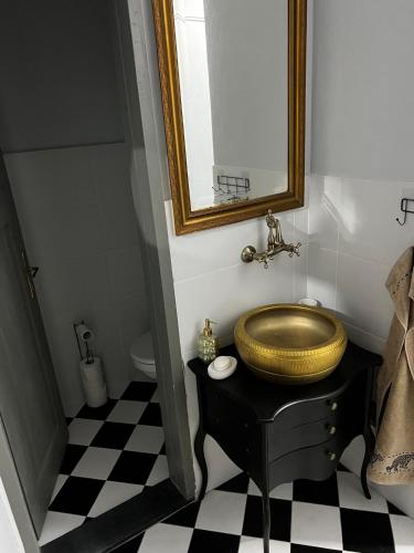 ein Badezimmer mit einem goldenen Waschbecken und einem Spiegel in der Unterkunft Petruccio in Zrenjanin
