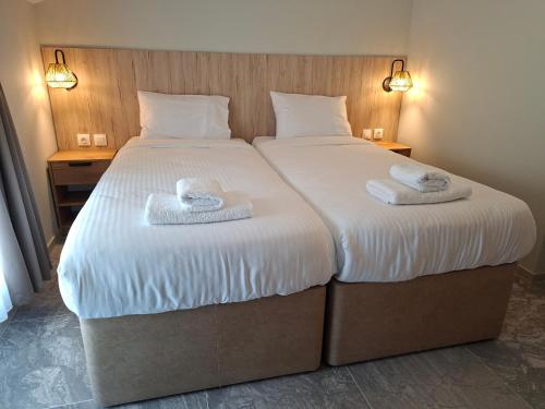 a bedroom with a large bed with towels on it at Enza Suites in Shumen