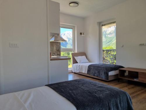 a hotel room with two beds and a window at Nana Time Guesthouse in Vusanje