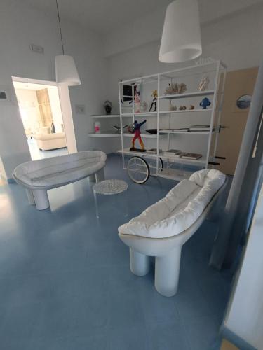 ein Zimmer mit zwei weißen Bänken und einem Regal in der Unterkunft Tuareg Hotel in Campomarino
