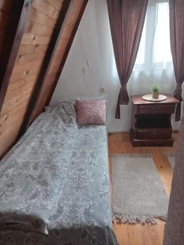 a bedroom with a bed and a table at Planinska Kuća Dušan in Mitrovac