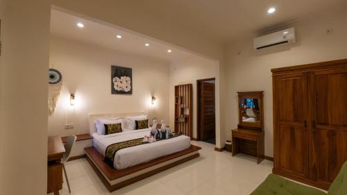 a bedroom with a bed and a desk in a room at Mango Garden in Gili Islands