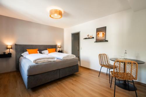 a bedroom with a bed and a table and chairs at Königslinde am Tegernsee in Bad Wiessee