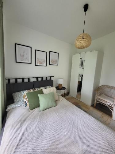 a bedroom with a large bed with green pillows at Jūras māja in Klapkalnciems