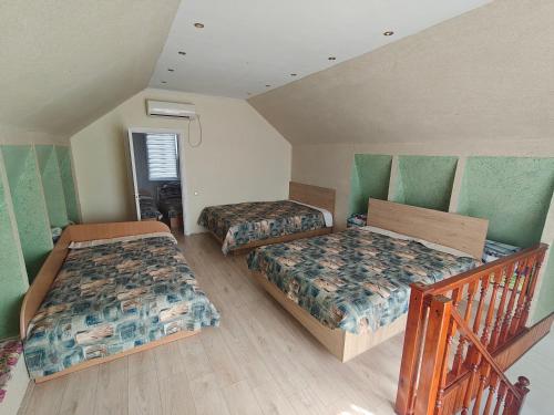 a bedroom with two beds and a staircase at Žangrija in Verbiškis