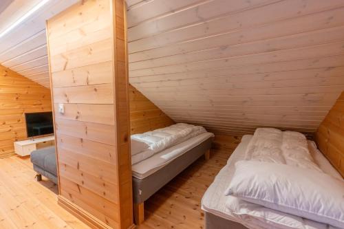 two beds in a room with wooden walls at Stranda Fjellgrend 36B in Stranda
