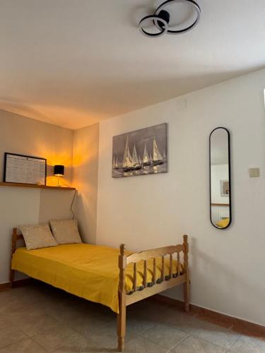 a bedroom with a bed with a yellow bedspread at Apartmani Grguric in Kornić
