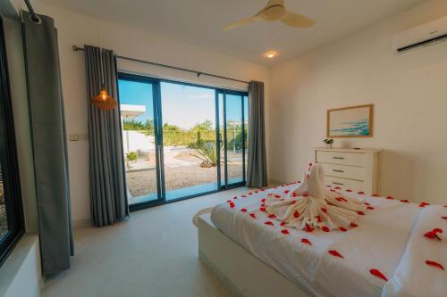 a bedroom with a bed and a large window at Casa Blanca Bweleo in Bweleo