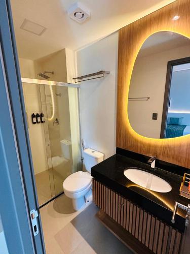 a bathroom with a toilet and a sink and a mirror at Wish Residence Ap 710 in Maceió