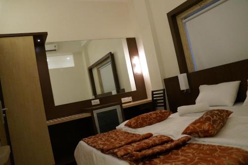 a bedroom with two beds and a large mirror at Nakshatra Residency in Ambernath
