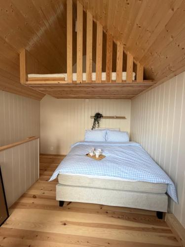 a bedroom with a bed with a wooden ceiling at Bird Nest in Bømlo