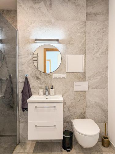 a bathroom with a sink and a toilet and a mirror at Cozy Apartment Kaija in Liepāja