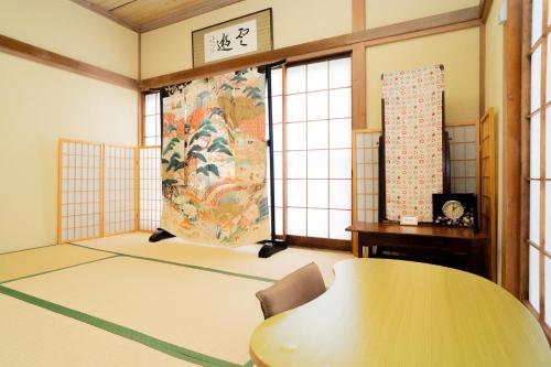 a room with a table and a large painting on the wall at HISAYO'S INN in Tokyo