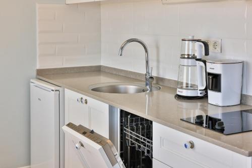 a kitchen counter with a sink and a coffee maker at Mavi Kıyı Suites in Kaş