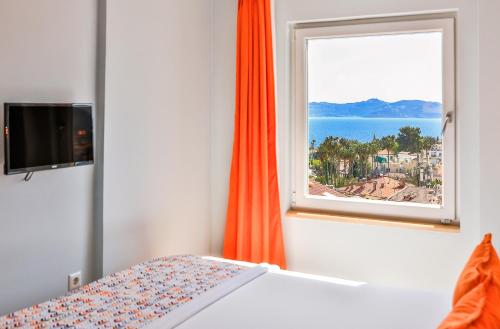 a bedroom with a window with a view of the ocean at Mavi Kıyı Suites in Kaş