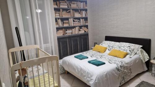 a bedroom with a bed with yellow pillows and a crib at Gîte à 15km PUY duFOU 5pers 3chambres in Pouzauges