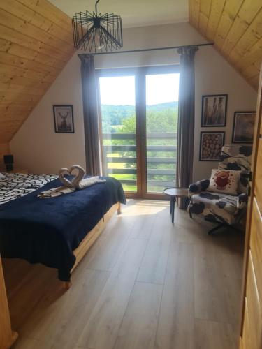 a bedroom with a bed and a large window at Domek na Czerwonej Górce in Uście Gorlickie