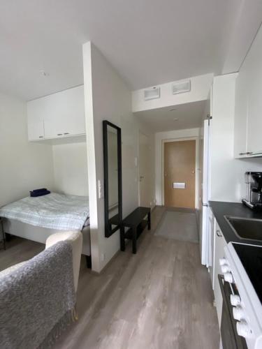 a small room with a bed and a kitchen at Moderni yksiö, omalla autopaikalla in Joensuu