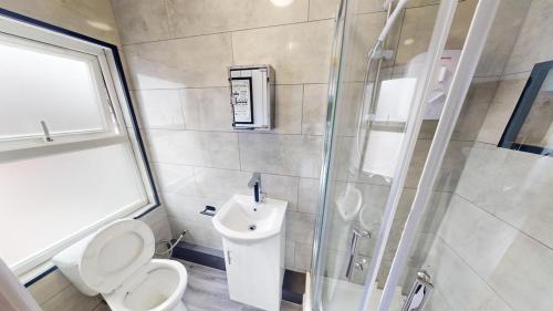 a bathroom with a shower and a toilet and a sink at The Lofton A Loft Above the Rest in Headingley