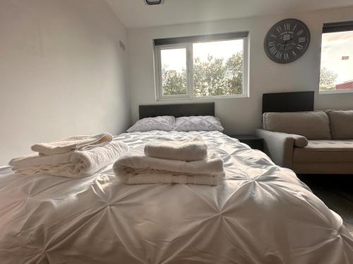 a bedroom with a large white bed with towels on it at The Lofton A Loft Above the Rest in Headingley
