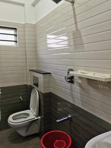 a bathroom with a toilet and a sink at Hotel Gateway Inn in Kushālnagar