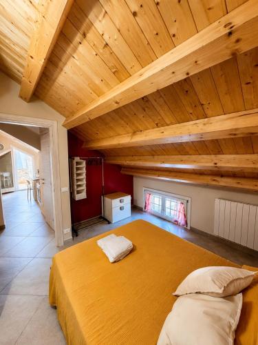 a large bed in a room with a wooden ceiling at Casa Vacanze Guccini in Porticello