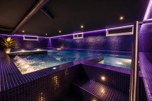 a swimming pool with purple lighting in a building at Villa BARLOVENTO SPA in Cambrils