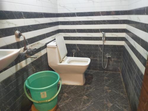 a bathroom with a toilet and a sink and a bucket at AA Grand in Hyderabad