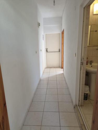 a hallway with a door and a tiled floor at ÖZNUR APART OTEL in Side