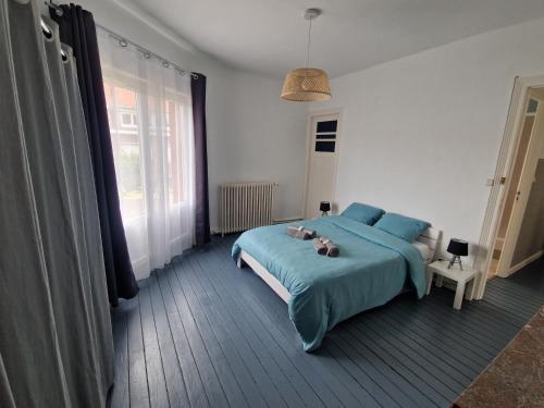 a bedroom with a bed with a teddy bear on it at Spacieux duplex familial proche Dunkerque et plage in Coudekerque-Branche