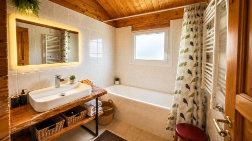 a bathroom with a sink and a bath tub at Chalet le Chal'Heureux in Mauroux