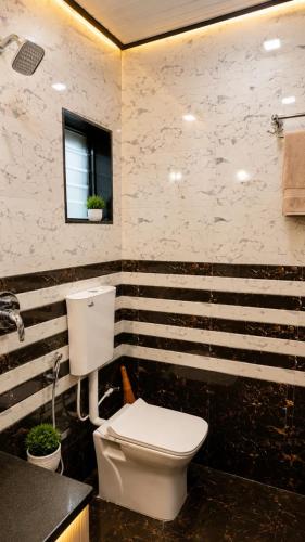 a bathroom with a white toilet and a sink at Garbat valley view Matheran in Matheran
