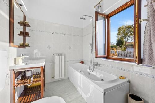 a white bathroom with a tub and a sink at Casa Fortunata in Kaštel