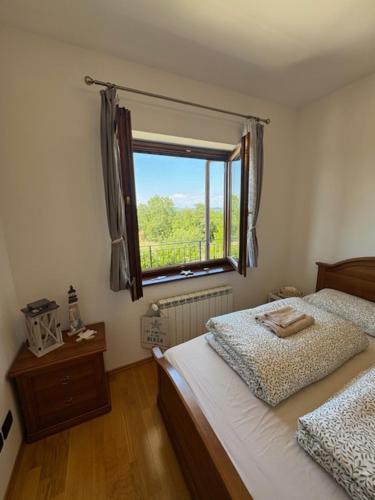 a bedroom with two beds and a window at Casa Fortunata in Kaštel