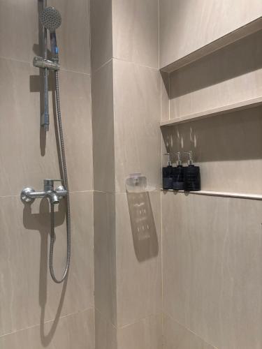 a bathroom with a shower with a shower head at Ocean View Corner Studio Private Balcony Tambuli Tower F in Maribago