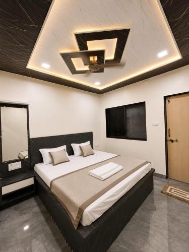 a bedroom with a large bed with a ceiling at Garbat valley view Matheran in Matheran