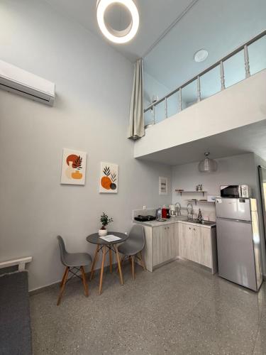 a kitchen with a table and chairs and a sink at Tête à Tête - Loft Apartment in Rhodes Town