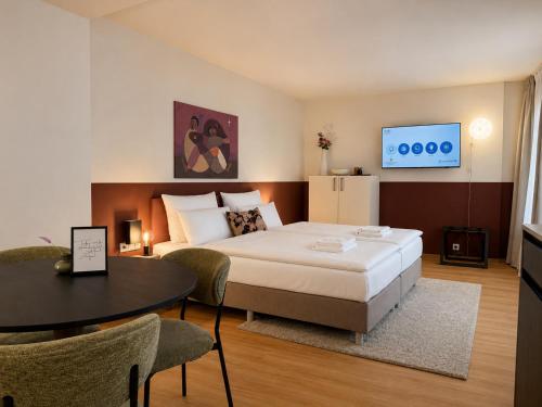 a bedroom with a bed and a table and a tv at Malerweg Residenz in Pirna